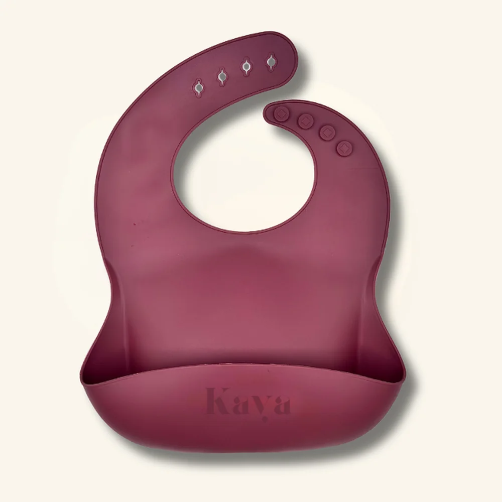 KAYA 2-pack of silicone baby bibs: a deep mauve bib and a cream bib with a cherry print, each with a food-catcher pocket